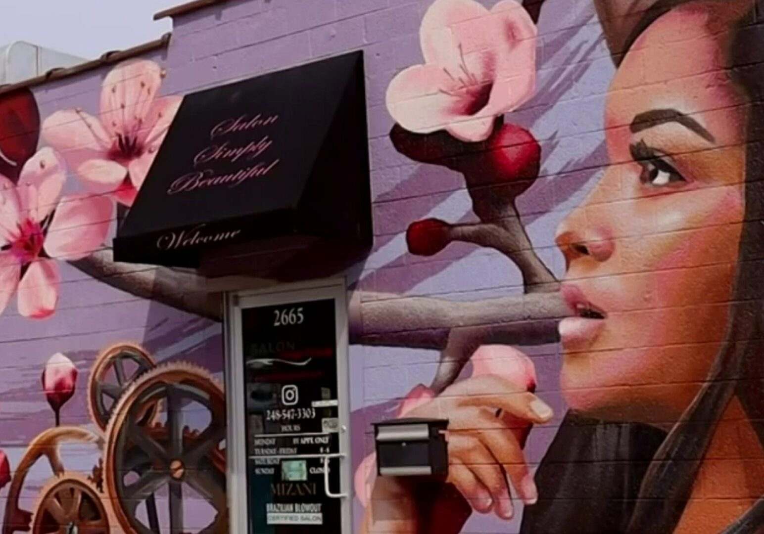 A woman holding a camera in front of a wall.